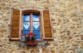 Pienza, Italy Ã¢â¬â July 22, 2017: Typical italian window with shutters on a stone wall in the ancient Tuscany town Pienza.